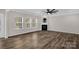 Sunlit living room with wood floors, fireplace, ceiling fan and large windows at 111 Bell Chase Ln, Statesville, NC 28677