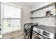 Laundry room with modern washer and dryer units, decorative wallpaper, and open shelving at 116 Dublin Ct, Statesville, NC 28677