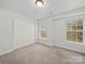 This bedroom features neutral carpet and white walls and trim, with windows and closet at 118 Glade Valley Ave, Mooresville, NC 28117