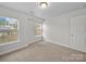 The bedroom boasts neutral carpet and white walls, complemented by natural light from two windows at 118 Glade Valley Ave, Mooresville, NC 28117