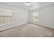 This bedroom offers neutral carpet, white walls, windows, and ample space for furniture and decor at 118 Glade Valley Ave, Mooresville, NC 28117