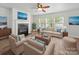 Cozy living room with a fireplace, ceiling fan, comfortable seating and natural light from the windows at 118 Glade Valley Ave, Mooresville, NC 28117