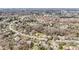 An aerial view of a residential area featuring a two-story home with a brown roof surrounded by blooming trees at 11929 Parks Farm Ln, Charlotte, NC 28277