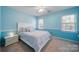 Bright bedroom with blue walls, carpet, and a comfortable bed and nightstand at 11929 Parks Farm Ln, Charlotte, NC 28277