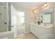 Bathroom featuring double sinks, a glass-enclosed shower, and neutral walls at 1309 Afternoon Sun Rd, Matthews, NC 28104