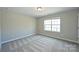 A well-lit bedroom featuring neutral paint, carpet flooring, and a single window at 1309 Afternoon Sun Rd, Matthews, NC 28104