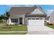 Charming single-story home with stone accents, white garage door, manicured lawn, and inviting entrance at 136 Adams Tree Way, Troutman, NC 28166