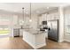 Modern kitchen with white cabinets, granite countertops, stainless steel appliances, and an island at 136 Adams Tree Way, Troutman, NC 28166