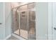 Modern bathroom with a glass enclosed shower, tiled walls, and shower bench at 1819 Lotus Ln, Denver, NC 28037