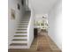 Bright entryway features hardwood floors, staircase, and view into the living area with ample natural light at 2004 Sadler Woods Ln, Charlotte, NC 28214