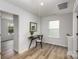 Bright hallway with wood floors, leading to bedroom and featuring desk and white walls at 2008 Sadler Woods Ln, Charlotte, NC 28214