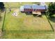 Aerial view of a fenced backyard, featuring a fire pit and wooden deck, great for outdoor gatherings at 2704 Silvers Ln, Albemarle, NC 28001