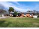 Charming single-story red brick home with a covered carport, a well-manicured lawn, and mature trees at 2704 Silvers Ln, Albemarle, NC 28001