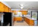 Well-lit kitchen with light wood cabinets, stainless steel appliances, tile floor, and a view of the backyard at 2704 Silvers Ln, Albemarle, NC 28001