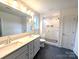 A bathroom with dual sink vanity and black hexagon tiles and large glass shower at 29069 Low Country Ln # 602, Lancaster, SC 29720