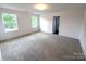A bedroom with two windows, light carpet and white walls and trim with a closet door at 29069 Low Country Ln # 602, Lancaster, SC 29720