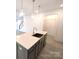 Close up of kitchen island with stone countertop, a stainless steel sink and modern fixtures at 29069 Low Country Ln # 602, Lancaster, SC 29720