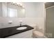 Bathroom with white tile walls, black countertop, shower, and classic fixtures at 340 Topsail Rd, Salisbury, NC 28146