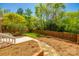 Fenced backyard with a brick paver path and mature trees at 4340 Sequoia Red Ln, Charlotte, NC 28226