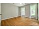 Bright bedroom featuring hardwood floors, two large windows, and neutral paint at 4340 Sequoia Red Ln, Charlotte, NC 28226