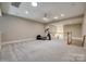 Large bonus room featuring plush carpet, a ceiling fan, and staircase to the second floor at 4340 Sequoia Red Ln, Charlotte, NC 28226