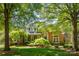 Charming brick home with mature trees, lush lawn, and manicured landscaping at 4340 Sequoia Red Ln, Charlotte, NC 28226