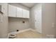 Bright laundry room offering built-in cabinet storage and wood-look flooring at 4340 Sequoia Red Ln, Charlotte, NC 28226