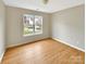 Cozy bedroom with a large window providing natural light, and hardwood flooring at 5928 Briggs Dr, Charlotte, NC 28269