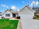 Charming single-story home featuring a well-manicured lawn, attached garage, and inviting front entrance at 5928 Briggs Dr, Charlotte, NC 28269