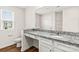 Well-lit bathroom featuring granite countertops, white cabinets, and a large mirror at 642 Lamorak Pl, Richburg, SC 29729