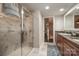 Bathroom with a walk-in shower with tile surround, wood vanity, and a granite countertop at 701 Royal Ct # 102, Charlotte, NC 28202