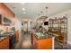 Open kitchen with stainless steel appliances, granite island, and dark hardwood floors at 701 Royal Ct # 102, Charlotte, NC 28202