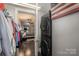 Laundry area with stacked washer and dryer units, a view into the closet and dark wood floors at 701 Royal Ct # 102, Charlotte, NC 28202