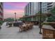Elegant outdoor dining area with large wooden table, chairs, and grill for entertaining at 701 Royal Ct # 102, Charlotte, NC 28202