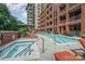Luxury pool and spa area with lounge chairs and the condo building in the background at 701 Royal Ct # 102, Charlotte, NC 28202