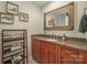 Powder room boasts a granite-topped wood vanity with an oversized mirror and tiled floors at 701 Royal Ct # 102, Charlotte, NC 28202