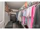 Walk-in closet features built-in shelving, dark wood floors and a bench at 701 Royal Ct # 102, Charlotte, NC 28202
