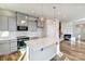 Modern kitchen featuring stainless steel appliances, a tile backsplash, gray cabinets, a quartz island and pendant lights at 8017 Downy Oak Ln, Charlotte, NC 28269