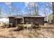 Cozy backyard view featuring a small deck, siding, and a tranquil, wooded environment at 8123 Chrisbry Ln, Charlotte, NC 28215