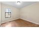 Bedroom with wood flooring, a large window, and neutral wall color at 8123 Chrisbry Ln, Charlotte, NC 28215