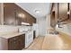 Traditional kitchen featuring white appliances, brown cabinets, and tile flooring at 8123 Chrisbry Ln, Charlotte, NC 28215