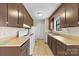 Traditional kitchen featuring white appliances, brown cabinets, and tile flooring at 8123 Chrisbry Ln, Charlotte, NC 28215