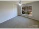 Bright bedroom featuring neutral carpet, a ceiling fan, and a window with neighborhood views at 1000 High Brook Dr, Waxhaw, NC 28173