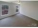 Bright bedroom features neutral carpet, a ceiling fan, and two windows with natural light at 1000 High Brook Dr, Waxhaw, NC 28173