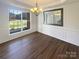 Formal dining room with hardwood floors, elegant wainscoting, and a large window overlooking the yard at 1000 High Brook Dr, Waxhaw, NC 28173