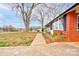 Brick home exterior featuring a sidewalk, garden bed, and lush green lawn at 107 Destiny Ln, Shelby, NC 28150