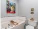 Bright bathroom featuring a large soaking tub with elegant tile accents and unique artistic decor at 1141 Hollyheath Ln, Charlotte, NC 28209