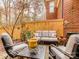Secluded brick patio features a comfortable seating area, charming garden decor, and a wooden privacy fence at 1141 Hollyheath Ln, Charlotte, NC 28209