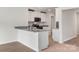 Bright kitchen with white cabinets, granite countertops, and a breakfast bar overlooking the living area at 117 Lightning Dr, Shelby, NC 28152