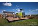 Community playground features a playset and picnic shelter on a mulched surface with a black fence surrounding it at 117 Lightning Dr, Shelby, NC 28152